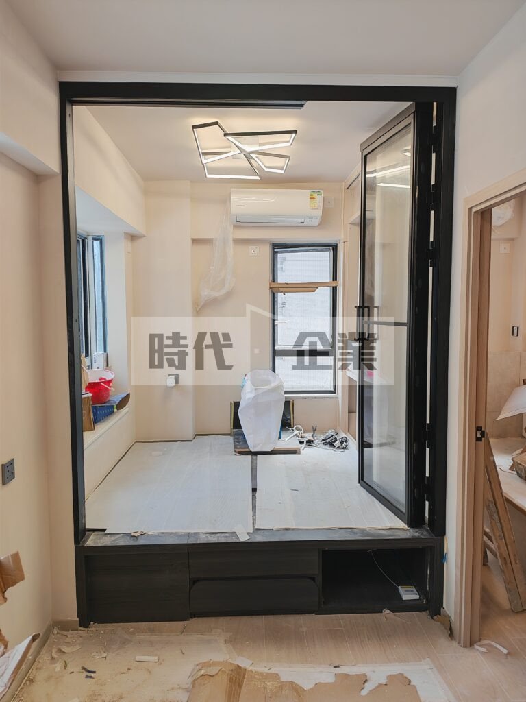 佐敦住宅客飯廳開放式地台床加裝不佔位3扇PD門趟掩門 黑色極窄邊框配透明強化玻璃 內鎖無地軌 做出可以完全開啟的門，節省出入空間