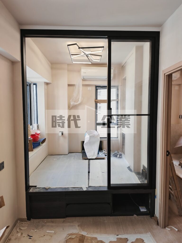 佐敦住宅客飯廳開放式地台床加裝不佔位3扇PD門趟掩門 黑色極窄邊框配透明強化玻璃 內鎖無地軌 做出可以完全開啟的門，節省出入空間